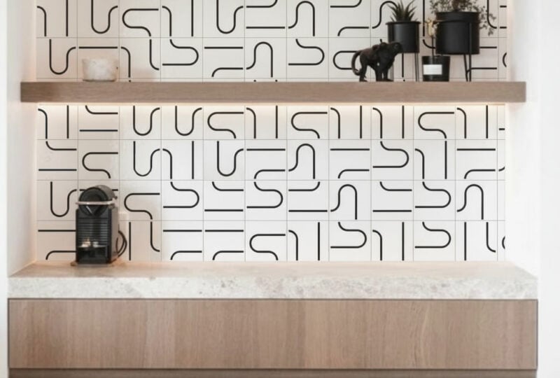 Parede de destaque em sala de estar com painel Linha Metro Preto TAI e aparador de café à frente